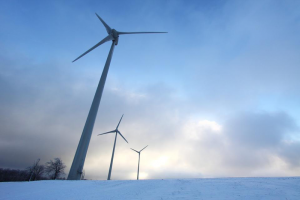 An image of a wind turbine  jutting out of a snowy landscape.