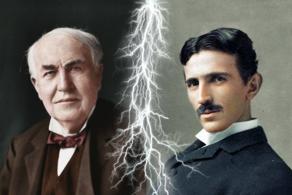 On the left is a photo of Thomas Edison, with gray hair and a brown suit. On the right is a photo of   Tesla, with black hair, a moustache, and a black suit. In between the two photos is a bolt of lightning. 