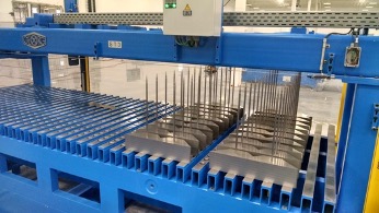 A scene from Corefficient's electrical transformer core manufacturing plant exhibiting the use of their GEORG TBA cutting lines to precisely cut and stack customizable transformer cores.