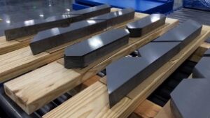 An array of polished STEP LAP FULL MITRE cores lying on wooden frames at Corefficient's electrical transformer core manufacturing plant.