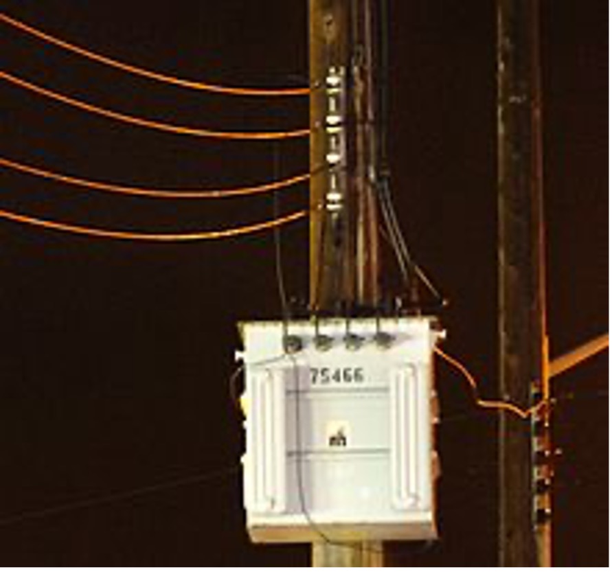 A three-phase transformer line with wires captured at nighttime.